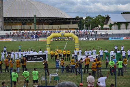 Jogadores com a faixa em apoio ao fim da violência contra a mulher.