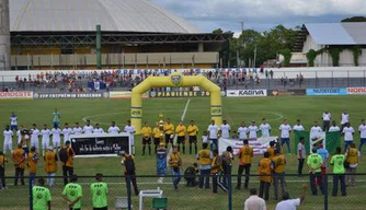 Jogadores com a faixa em apoio ao fim da violência contra a mulher.