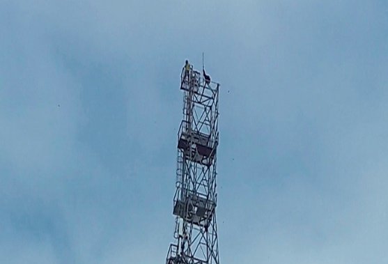 Homem em torre de 80 metros de altura.