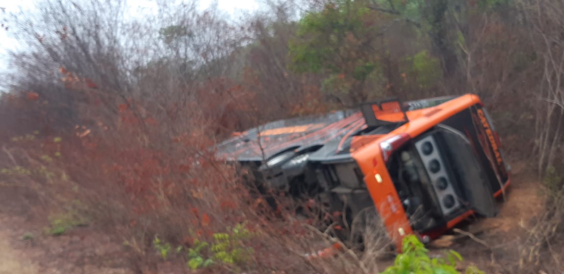 Ônibus tombado fora da pista.