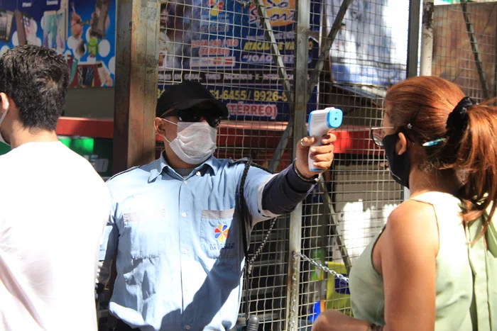 Equipes aferindo a temperatura dos clientes antes de adentrar no Shopping da Cidade.