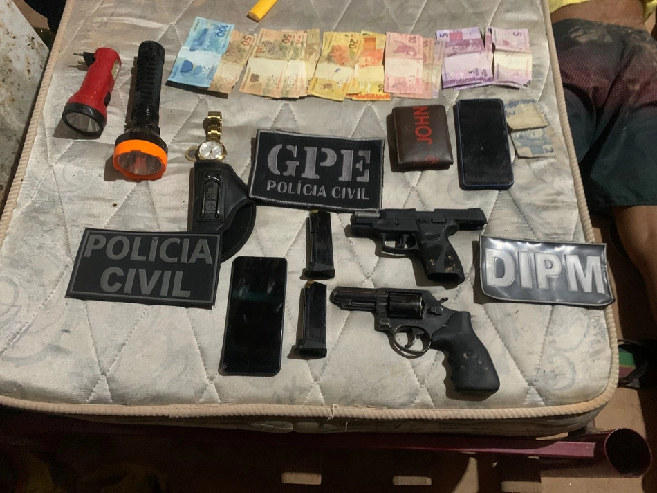 Armas de fogo e dinheiro apreendidos durante mandado de busca e apreensão.