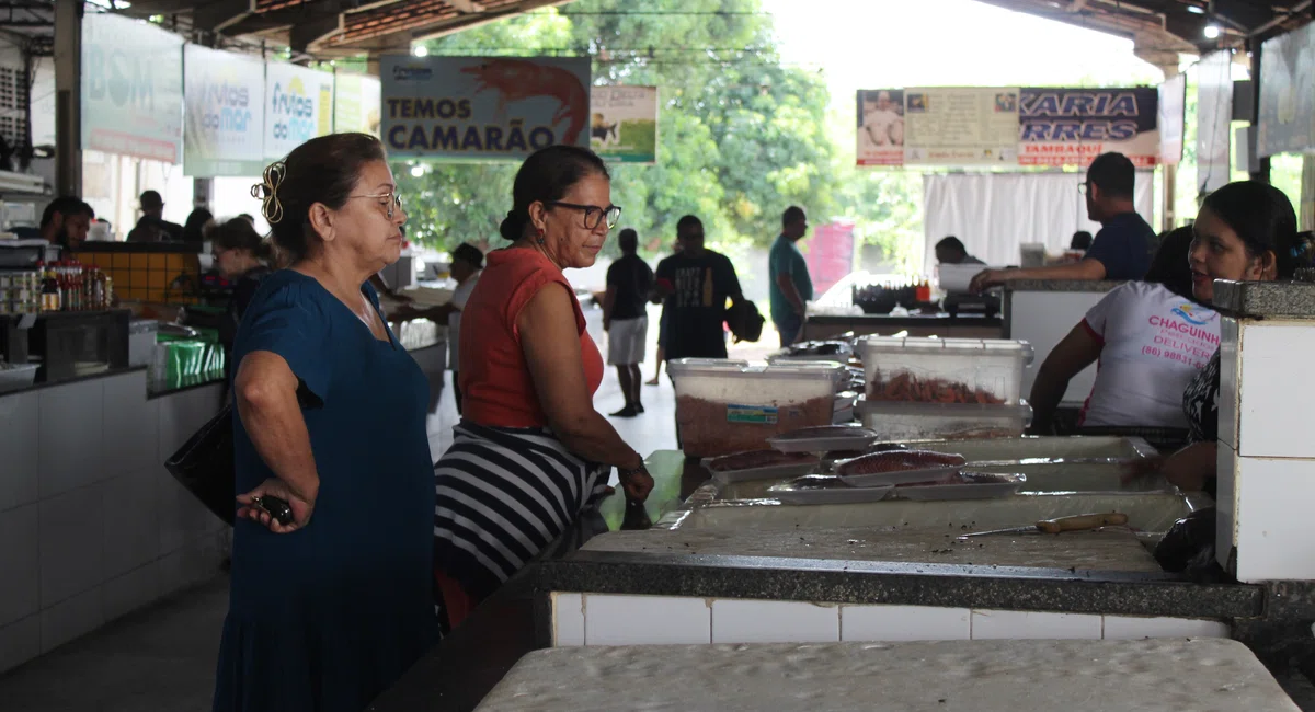 Clientes consultam preços no Mercado do Peixe