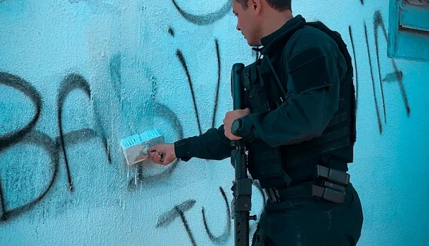 Delegado Charles Pessoa removendo pichações com siglas de facções