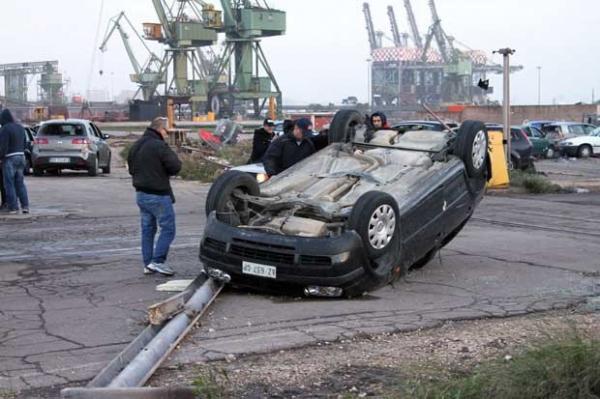 Homens observam carro capotado por fenômeno em Taranto nesta quarta-feira(Imagem:Reprodução)